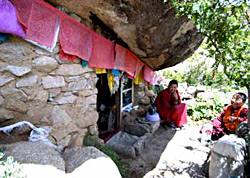 Nuns sit outside one of the mkhar rdo caves. Nuns are the only residents of the site today.